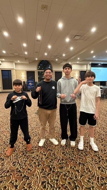 Orion with the youth minister and two boys from the group, each holding a rosary.